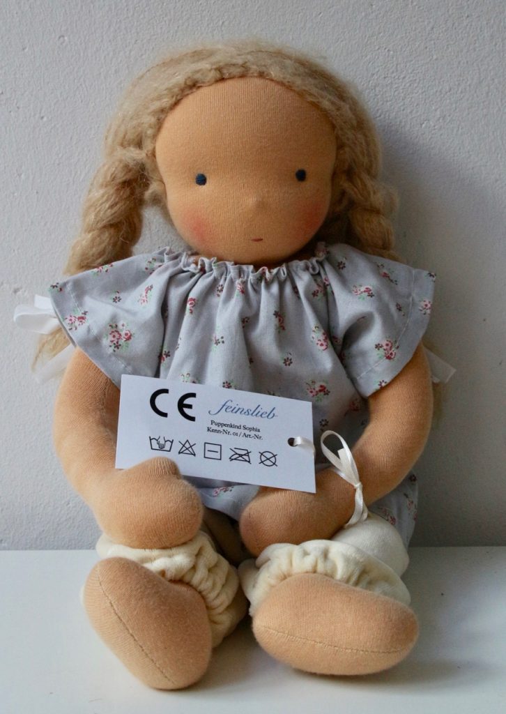 Stoffpuppe / Puppe / Waldorfpuppe mit CE-Etikett. Darauf: Die Textilpflege-Symbole korrekt angeordnet.
