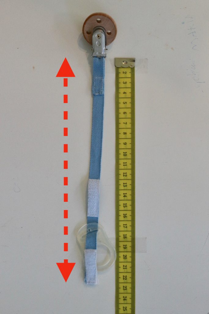 Schnullerketten Länge richtig messen: Schnullerkette (Beispiel) neben Maßband und Pfeil, welche Länge gemessen werden muss.