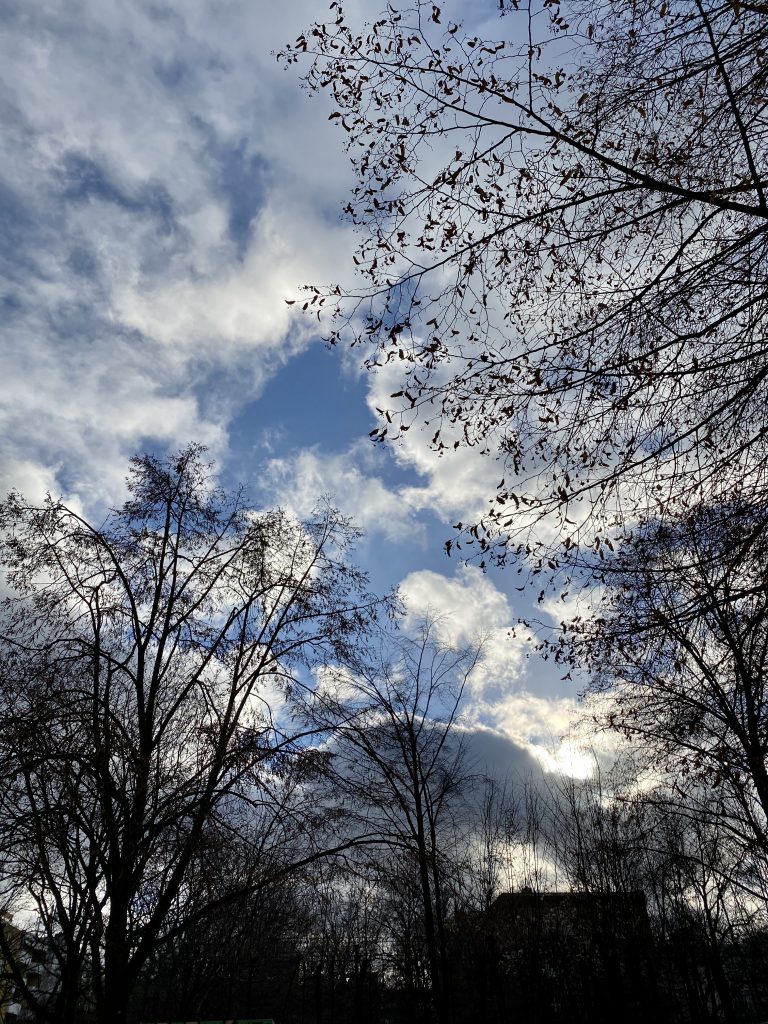 Winterhimmel über Stadtsilhouette, blauer Himmel mit Wolken im Gegenlicht