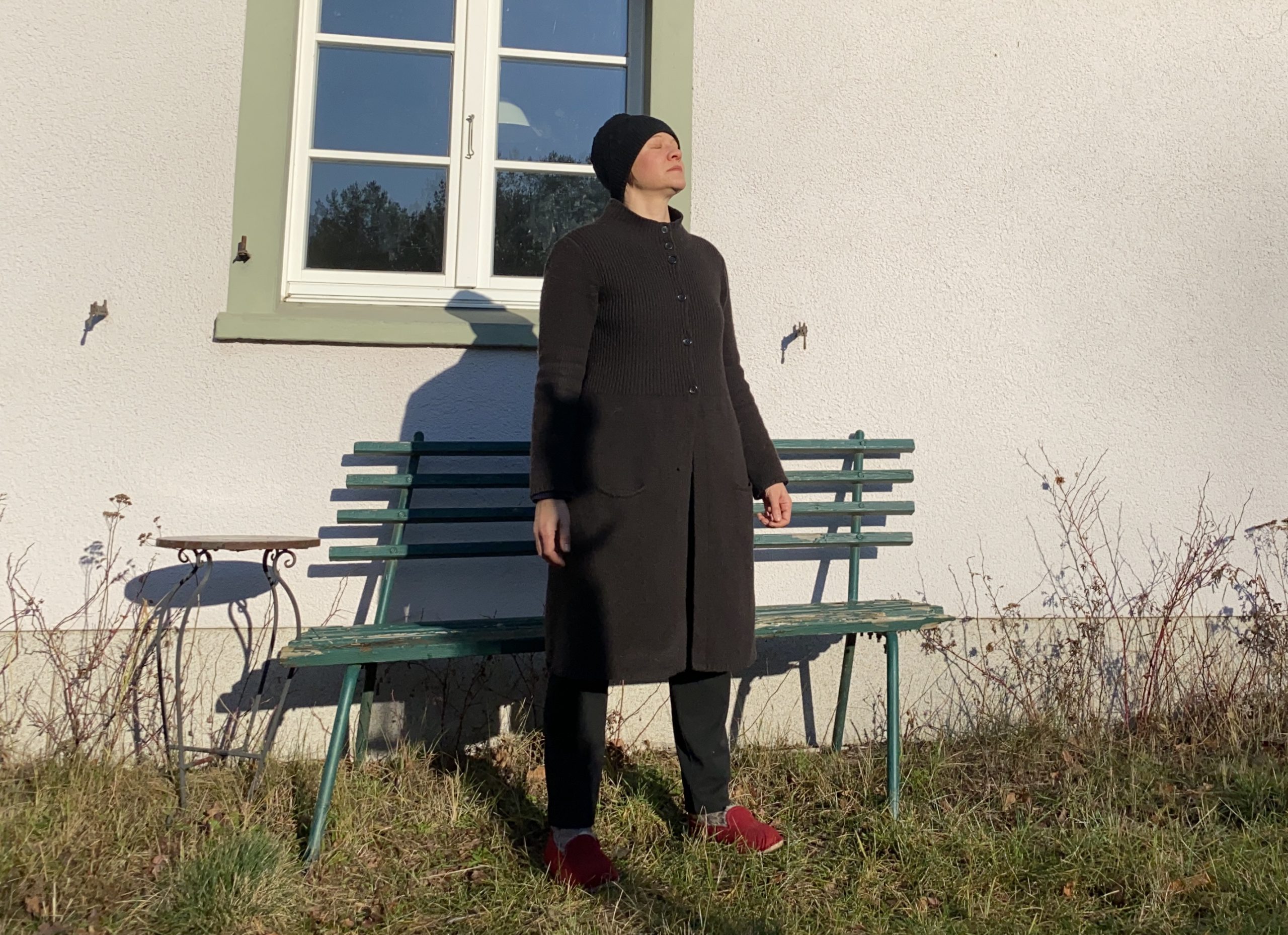 Ich mit herunter hängenden Armen in die Sonne schauend