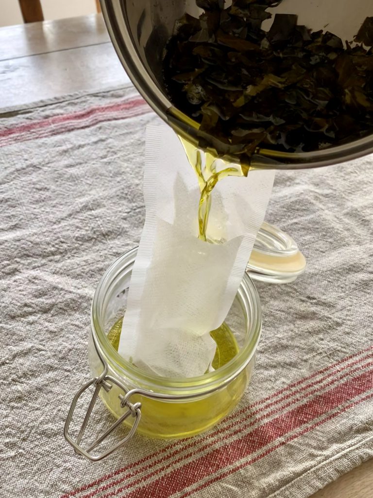 Peeling selber machen: Efeu in Öl wird durch Teefilter in ein Schraubglas abgeseiht. Das Efeu-Öl ist die Grundlage für das Peeling.