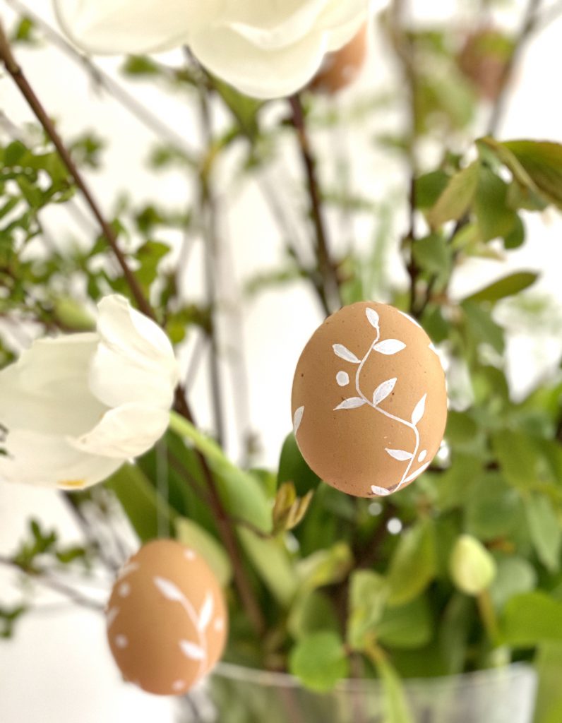 braune Eier am Osterstrauß mit Blumenranken und Punkten