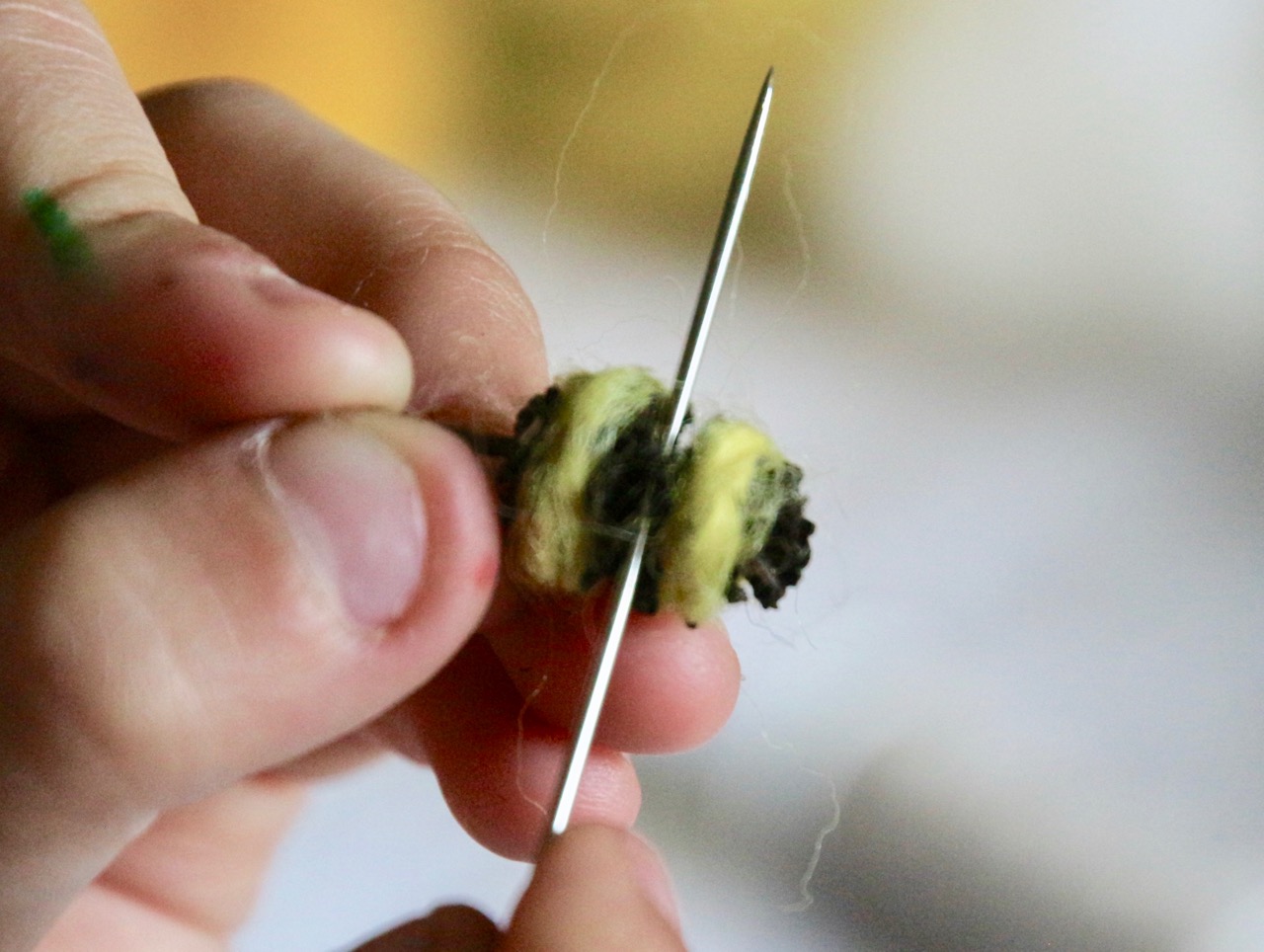 selbst gebastelte Biene aus Erlenzapfen, Nadel sticht durch Zapfen