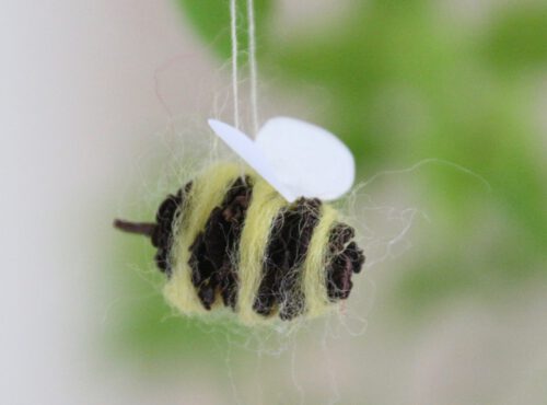 Bienen basteln aus Erlenzapfen: Biene nah vor Grün