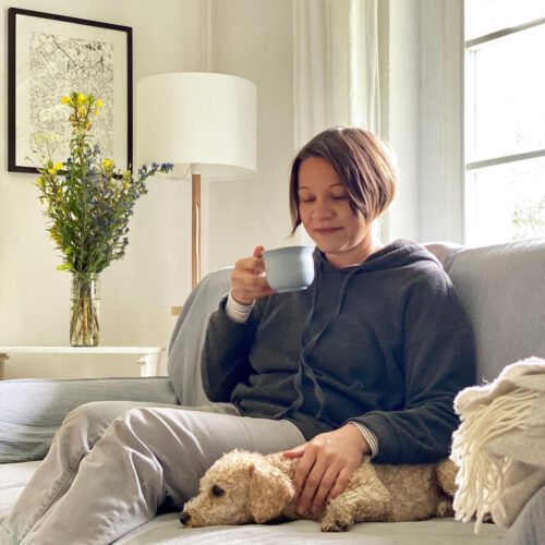 Maike auf dem Sofa, mit Teetasse und Hund