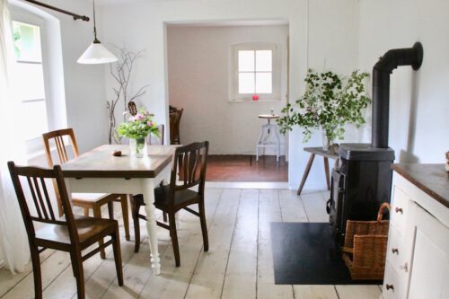 Esszimmer mit Holzofen und altem Tisch
