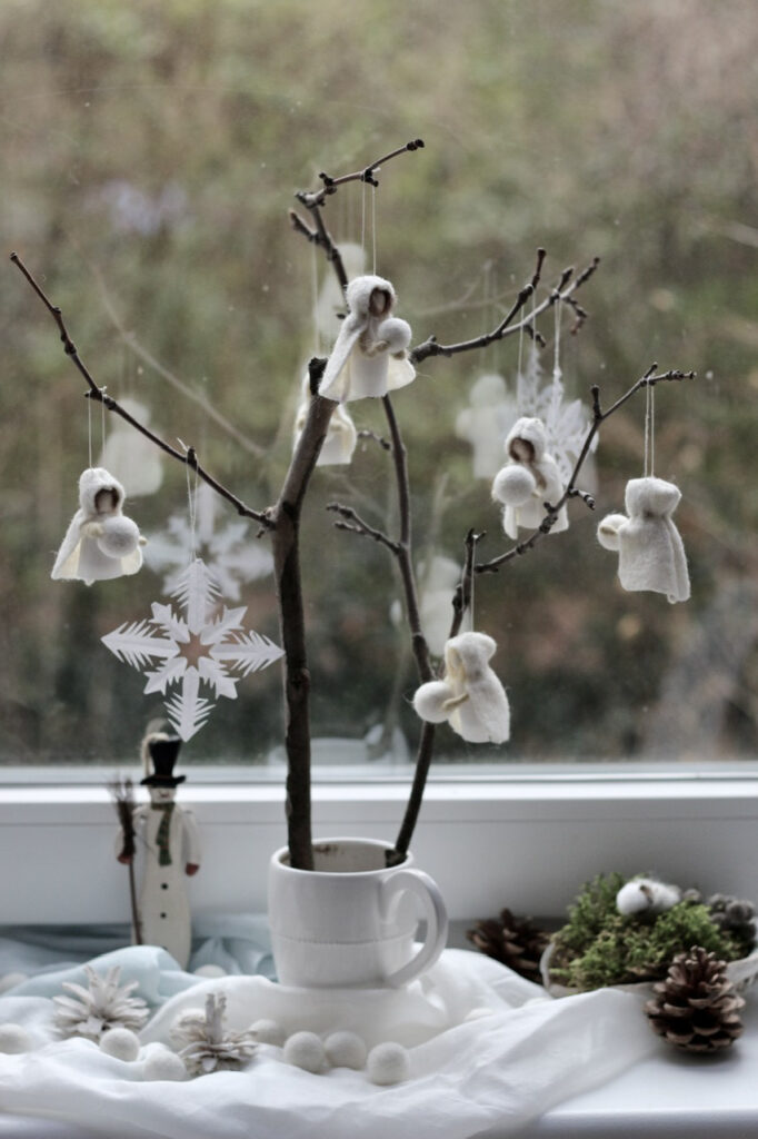 Jahreszeitentisch Puppen Typ Winter / Schneeflockenkinder 5 Stück an kahlem Zweig vor Fenster