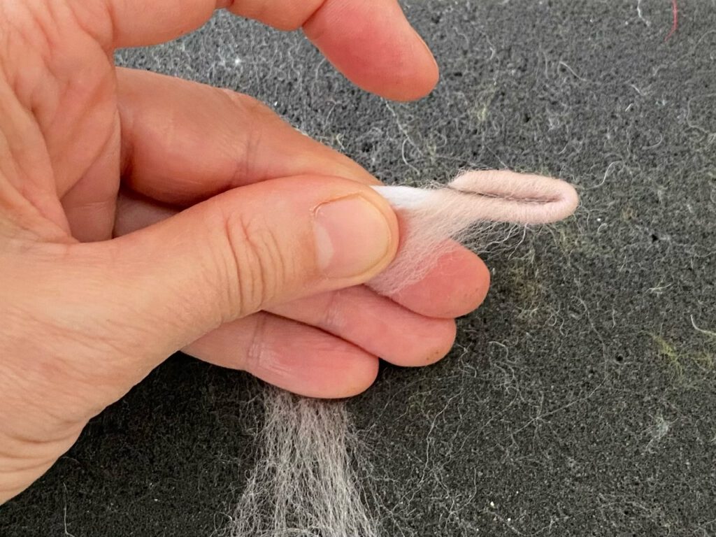 Blumenkind filzen: Ende von Pfeifenputzer mit Wolle umwickelt, ein Stück umgebogen