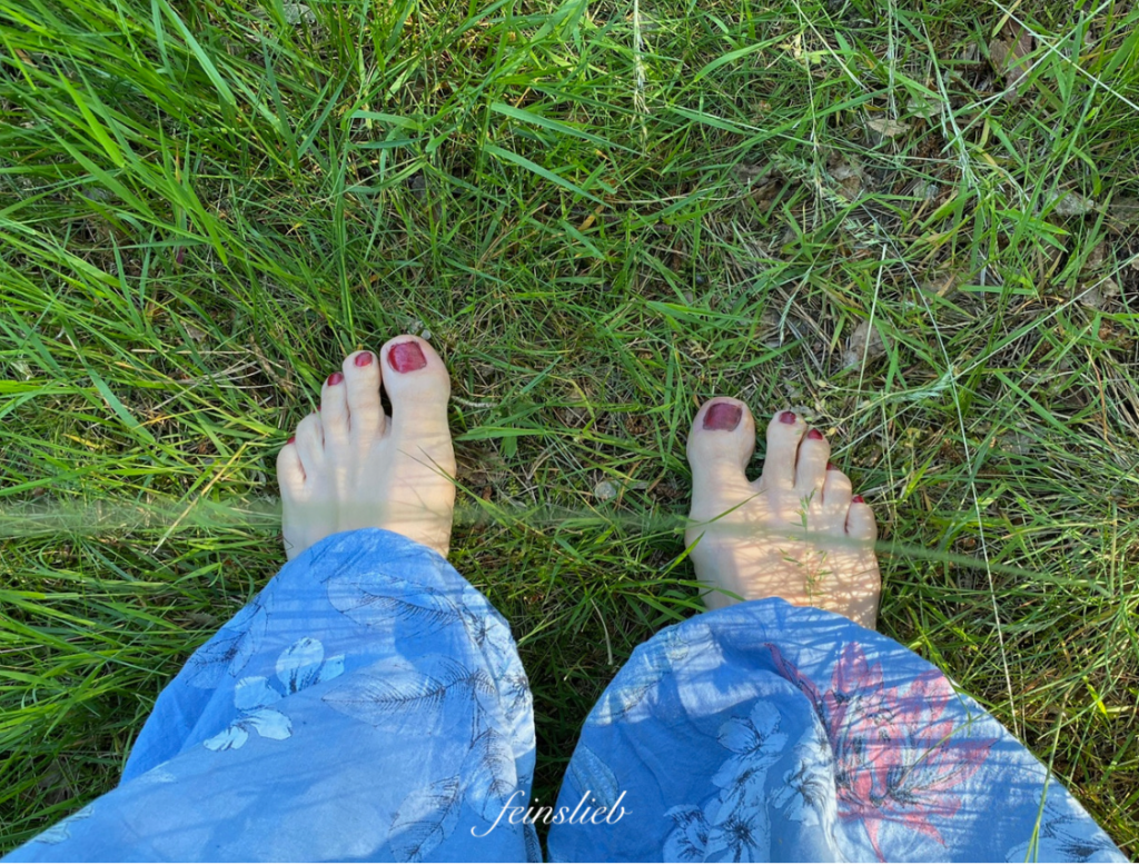 Mein perfekter Tag im Juni 2021 startete mit einem Barfußspaziergang. Auf dem Bild: Nackte Füße in blauer Hose von oben im Gras.