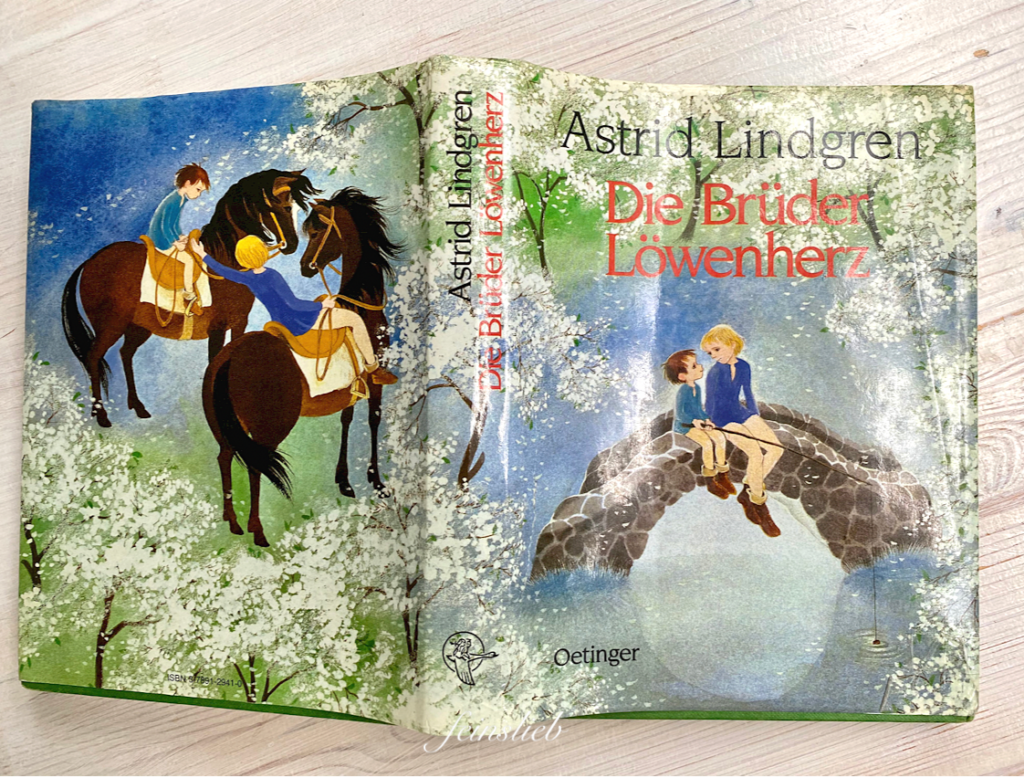 Cover des Buches "Die Brüder Löwenherz" von Astrid Lindgren, das Buch aufgeklappt auf die Seiten gelegt.