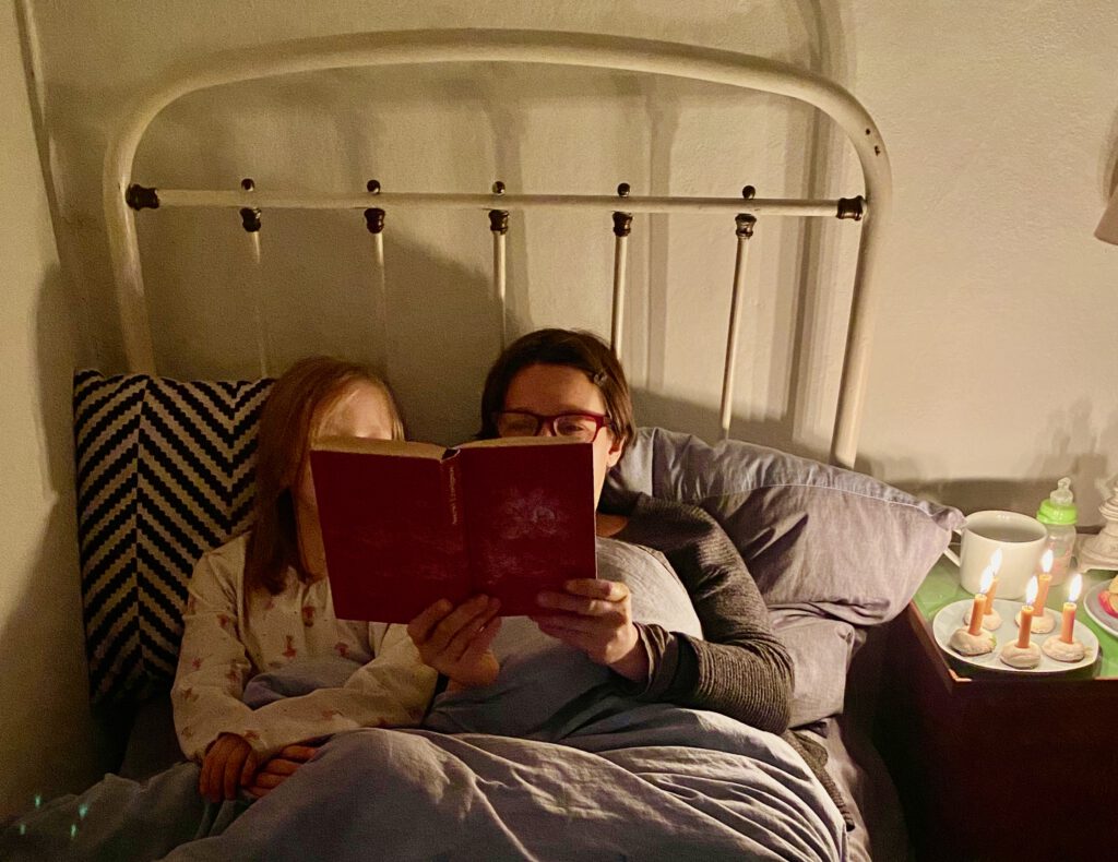 Weihnachten ohne Stress geht gut, wenn man wie ich hier mit der Tochter im Bett liegt und ein Buch vorliest. Mit Kerzen auf dem Nachttisch.