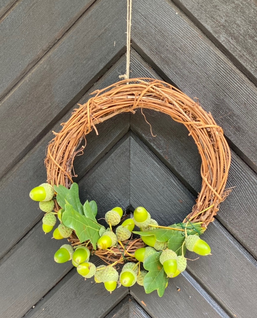 Basteln mit grünen Eicheln Idee 3: Türkranz an brauner Tür mit grünen Eicheln und Eichel-Blättern