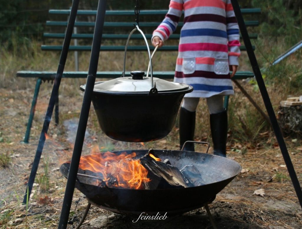 Kind kocht Suppe über Feuerschale
(September Ideen für Aktivitäten mit Kindern)