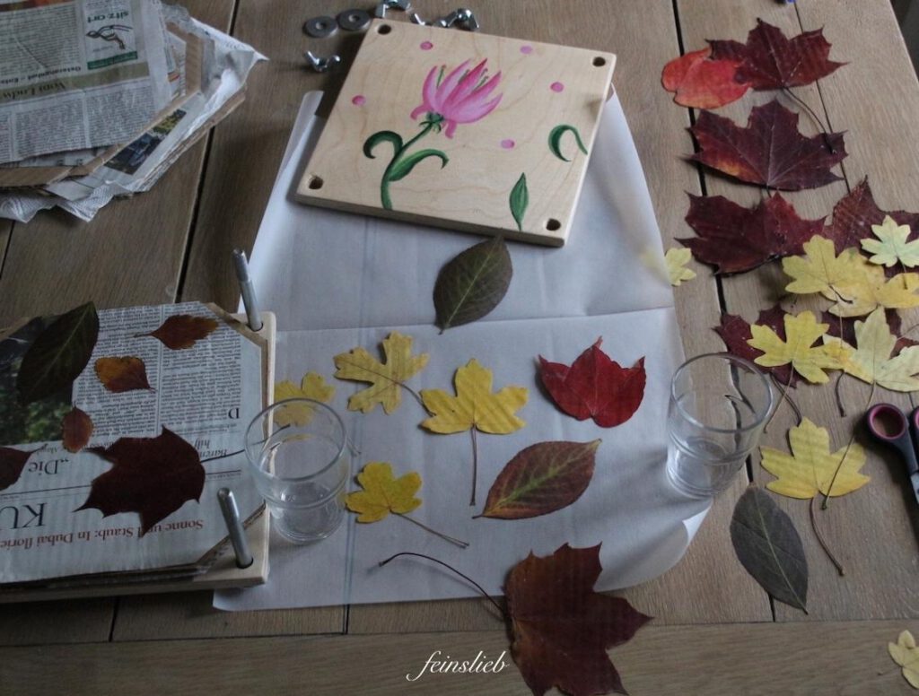 Oktober mit Kindern - Ideen: gepresste Blätter und Pflanzenpresse auf Holztisch