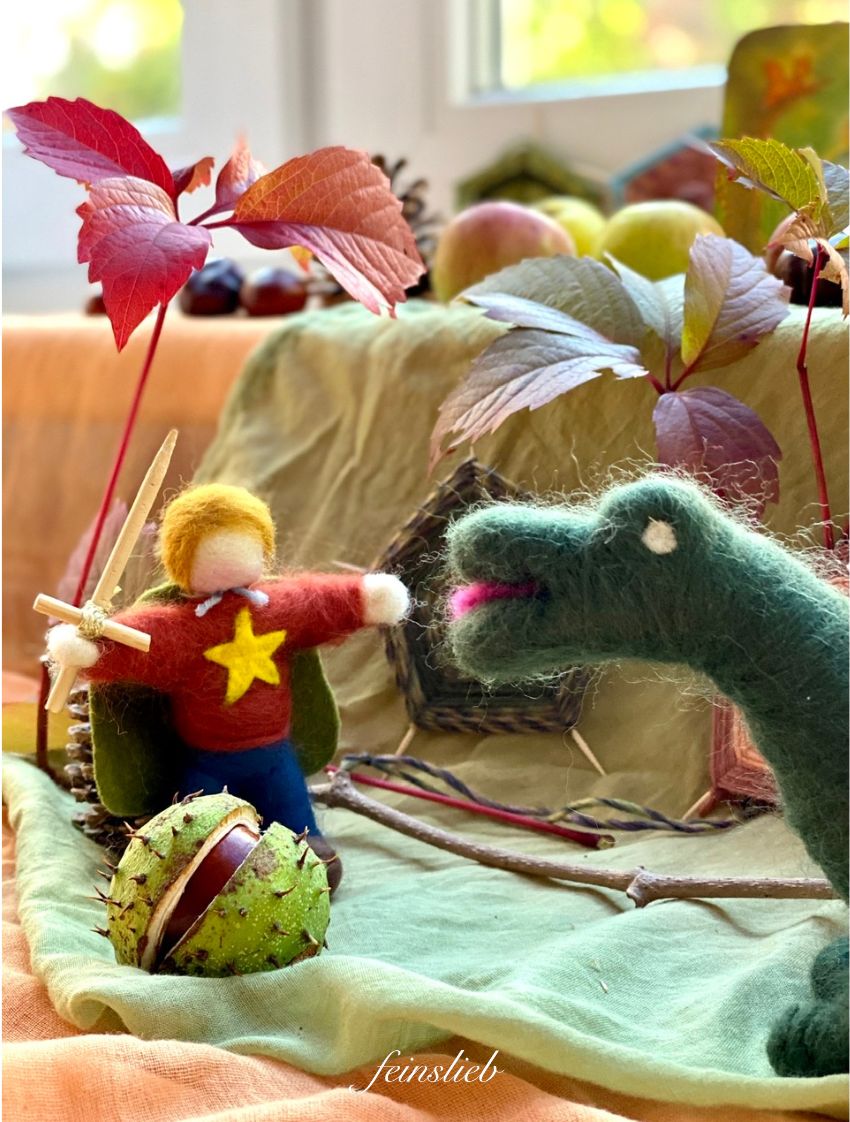Jahreszeitentisch Michaeli: Michaels-Figur aus Filz und Drachen aus Filz auf Tüchern, mit Weinlaub und Spinnennetzen aus Wolle