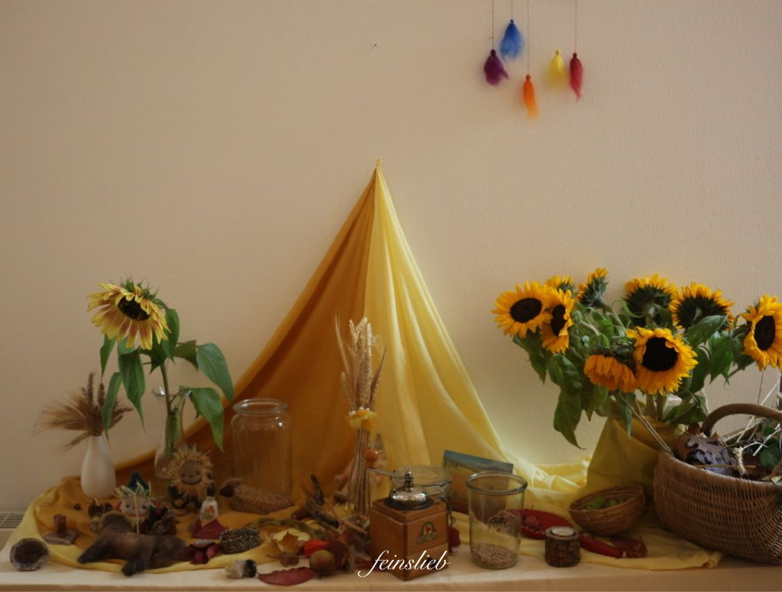 Jahreszeitentisch September / Spätsommer mit gelbem Tuch, Sonnenblumen, Getreideähren, kleinen Wollzwergen