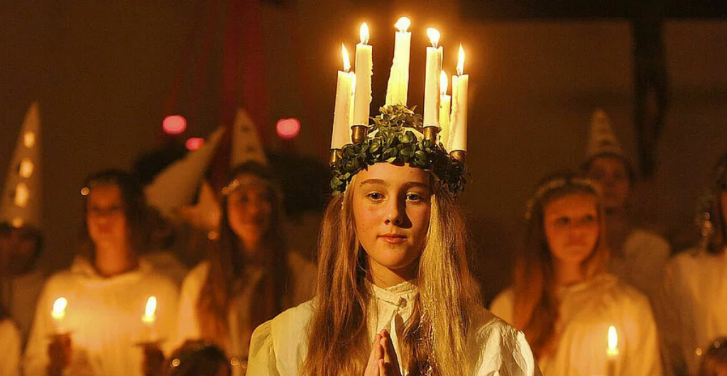 Eine Lucia Braut mit weißem Kleid und Lichterkrone (Kerzen)