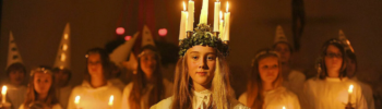 Eine Lucia Braut mit weißem Kleid und Lichterkrone (Kerzen)