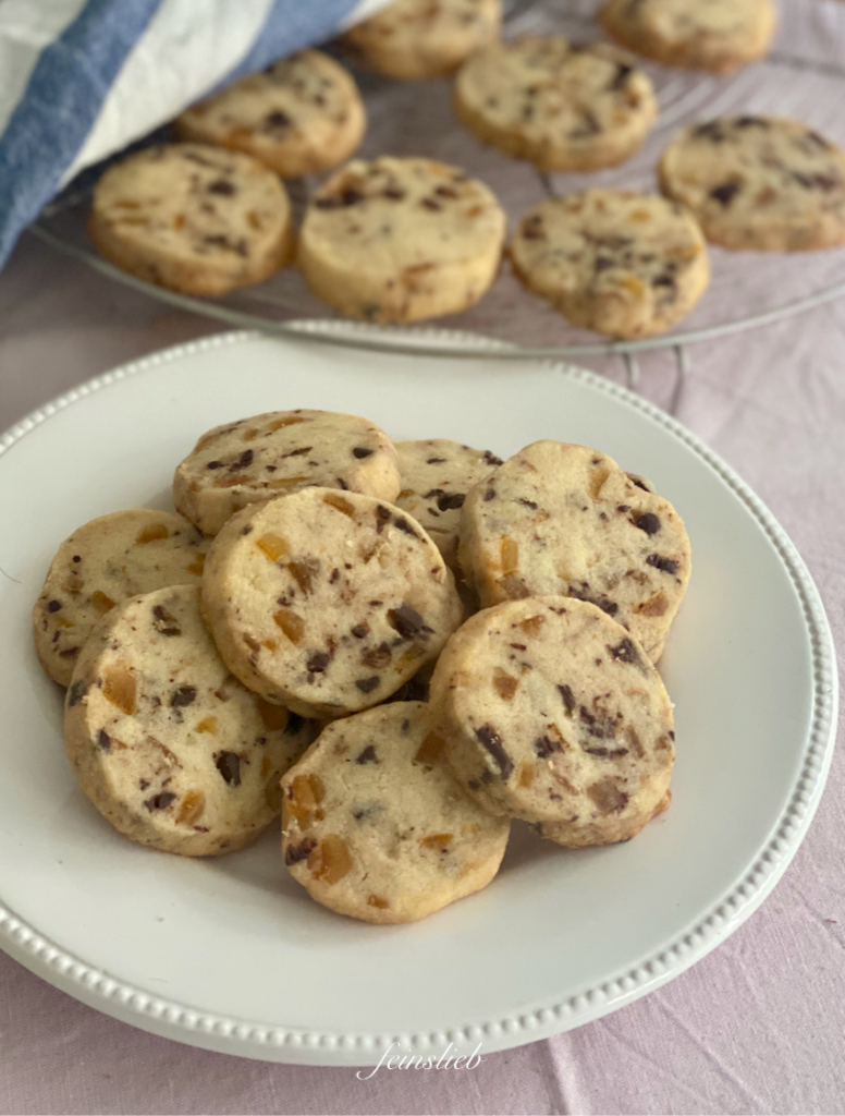 12 Shortbread-Cookies mit Orange und Schokolade auf weißem Teller