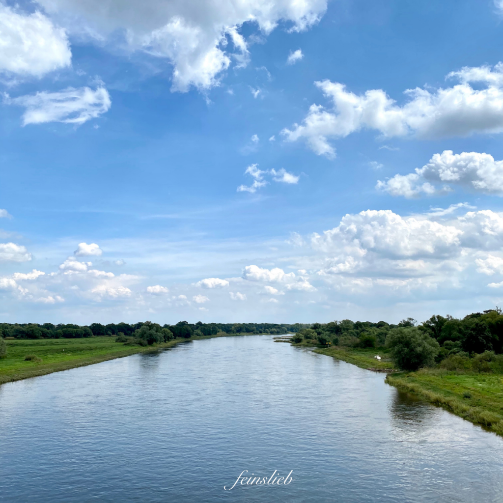 breiter Fluss mit blauem Himmel darüber im Juli